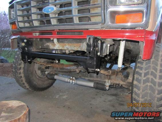 1980 Ford Bronco front grille, bumper, and suspension components. Red fender visible