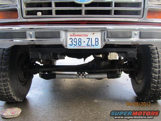 Front axle, steering linkage, and tires of a Ford truck. Washington license plate 398-ZLB is visible