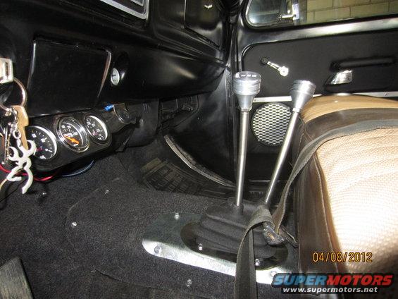 Interior view of a 1979 Ford Bronco showing the dashboard, two gear shifters, and auxiliary gauges