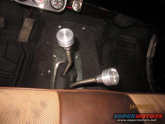 Vehicle interior with two chrome gear shifters, one labeled 'HI' and 'LO', and a dated watermark