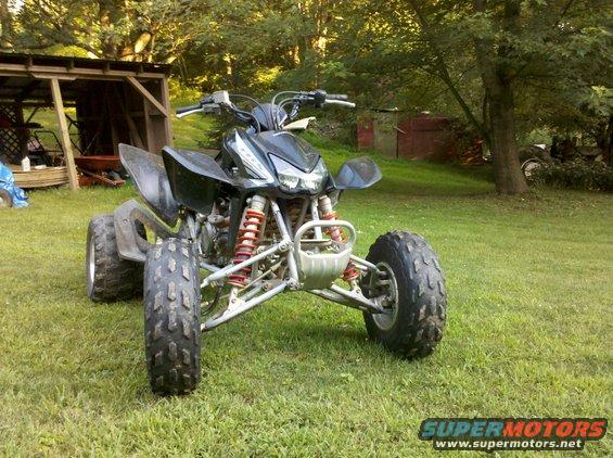 2005 Honda TRX 450 R ATV parked on grass in front of a wooden structure