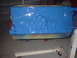 1957 Ford Custom Sedan - A freshly painted blue engine block sits on a stand in a garage, showing signs of previous colorful primer.