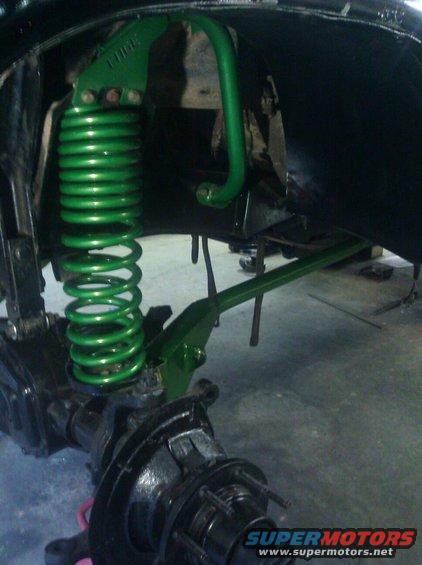 Green coil spring and sway bar on a vehicle axle