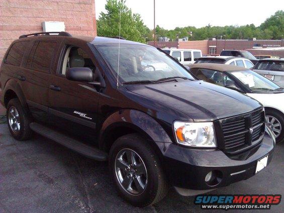 Black SUV with chrome wheels, side step, and 'Night Runner' badge parked outdoors