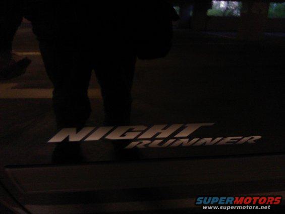 Silver 'Night Runner' text emblem on a dark background