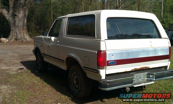 White 1987 Ford Bronco rear view with red and silver trim
