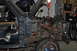 1986 Ford Bronco - Disassembled blue Ford Bronco with engine bay exposed and significant rust visible on the frame.