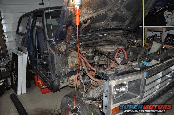 1986 Ford Bronco engine bay with hood open, showing engine and front grille