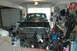 1986 Ford Bronco - The front of a Ford Bronco is visible in a garage, surrounded by various items and sporting equipment.