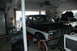1986 Ford Bronco - A two-tone 1986 Ford Bronco is parked inside a garage with its hood open.
