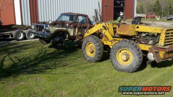 Rusted 1979 Ford pickup chassis with front loader attachment
