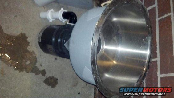 Pool pump and filter assembly with a stainless steel basin and black motor, resting on concrete with water stains