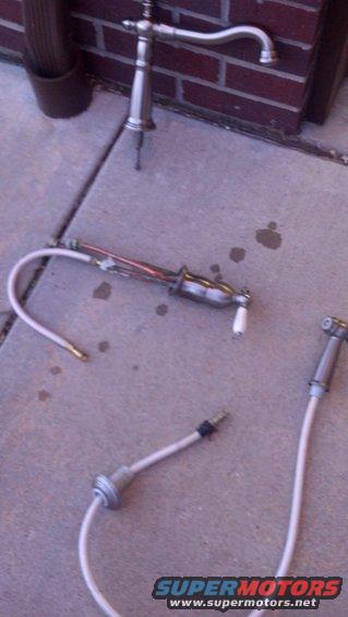 Plumbing faucet and bidet sprayer parts on concrete
