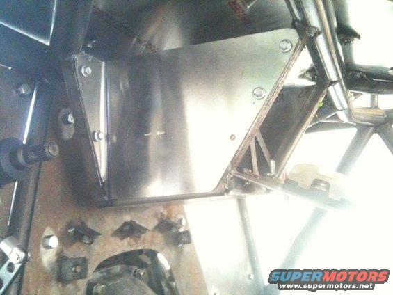 Custom metal fabrication inside a vehicle, showing bolted panels and structural supports