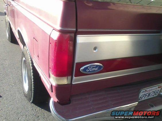 Red 1991 Ford Bronco rear quarter panel with Ford logo and license plate 6PFN758