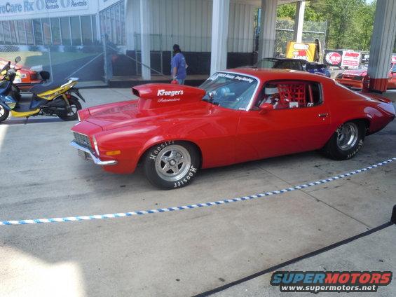 Red drag car with large hood scoop and roll cage, Hoosier tires