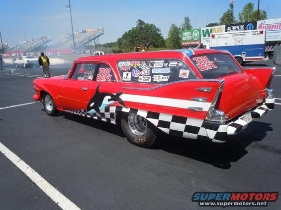 red station wagon with orca and checkered flag graphics, racing slicks, at a drag strip