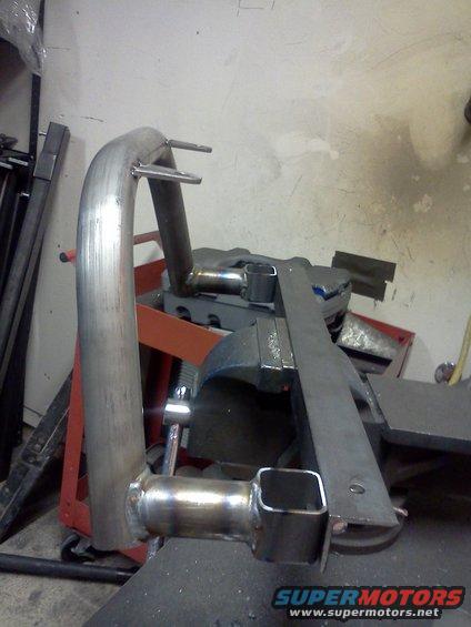 Custom exhaust pipe section clamped in a vise