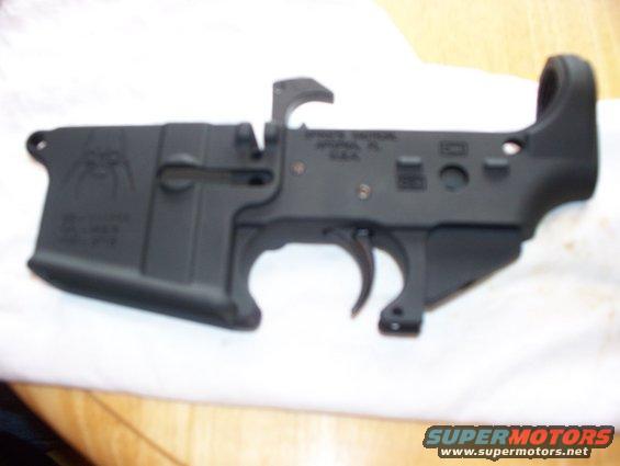 Black AR-15 lower receiver with spider logo and text