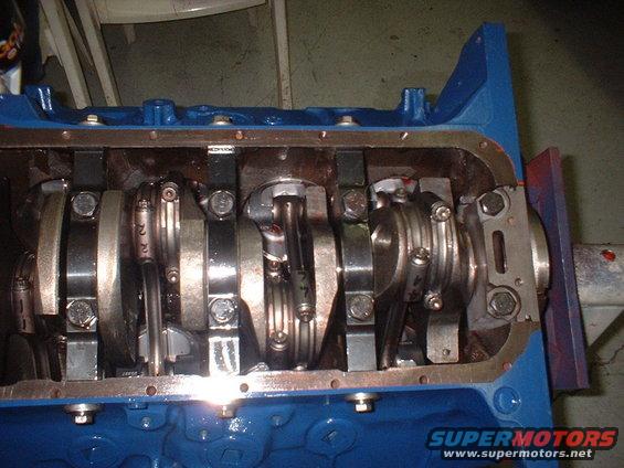 Engine block with crankshaft and connecting rods visible. Some rods have numbers like '22' and '77'
