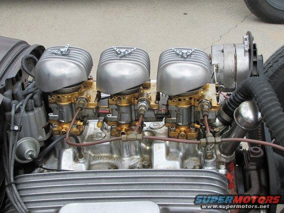 Close-up of a V8 engine with three Edelbrock carburetors and finned air cleaners