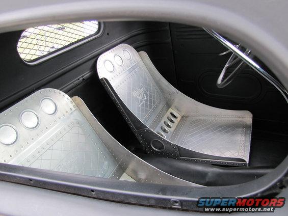 Two custom aluminum racing seats with diamond plate patterns and visible rivets inside a vehicle