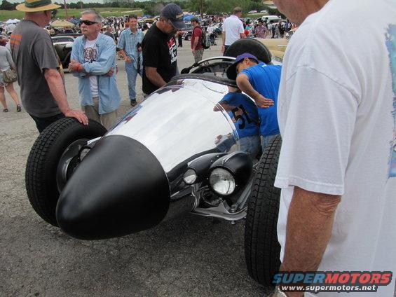 Custom hot rod with exposed front wheel, chrome nose cone, and dual headlights