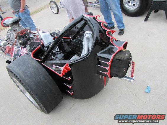 Black dragster with red flame graphics and a large rear tire