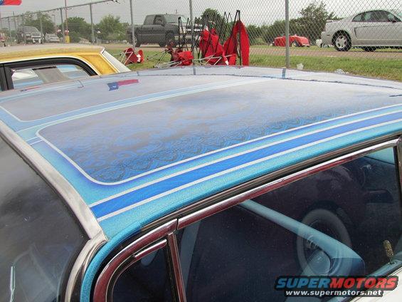 Blue custom painted car roof with pinstripes and a Texas flag reflection
