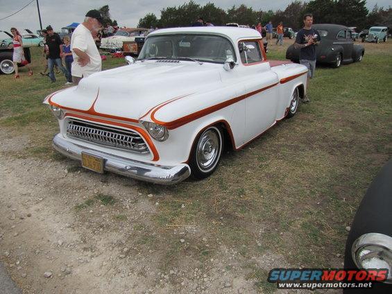 White and orange custom pickup truck front 3/4 view with chrome grille and orange pinstriping