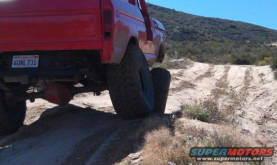 Red 1978 Ford Bronco rear view on off-road trail