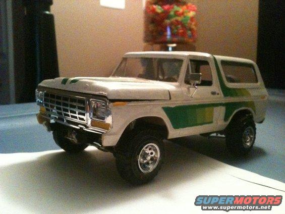 White model truck with green stripes, chrome grille, and off-road tires