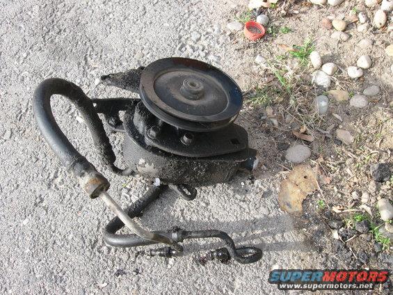 power steering pump with pulley and hoses, sitting on the ground