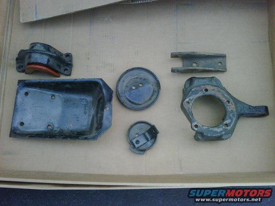 Several assorted metal automotive parts laid out in a box