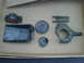 1996 Ford Bronco - Assorted metal automotive parts are displayed in a cardboard box.