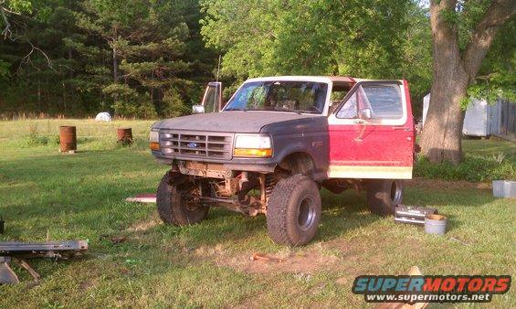 Ford Bronco with mismatched front clip, lifted suspension, and red passenger door