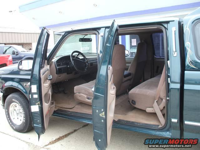 Green crew cab truck interior with all doors open, showing front and rear seats