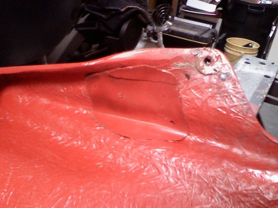 Cracked red plastic part with visible damage and mounting hole