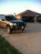 2004 Ford F-150 - A gold Ford F-150 pickup truck is parked in a driveway with a brick house in the background.