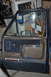 1986 Ford Bronco - Interior of a car door, dark blue and brown upholstery with chrome trim. A small sticker is visible near the bottom.