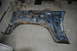 1986 Ford Bronco - This heavily rusted blue fender assembly is a vehicle part, not a complete vehicle.