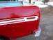 1978 Ford F-250 - Rear corner of a red pickup truck bed, showing damage and a white stripe detail.