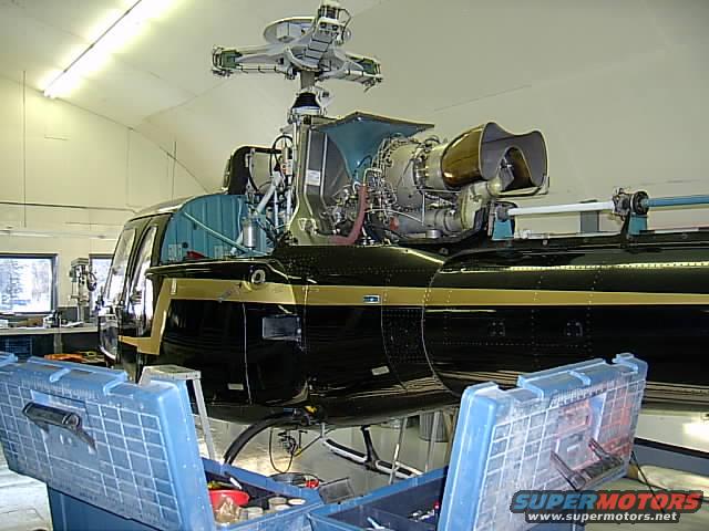 Helicopter with engine exposed, tools in foreground
