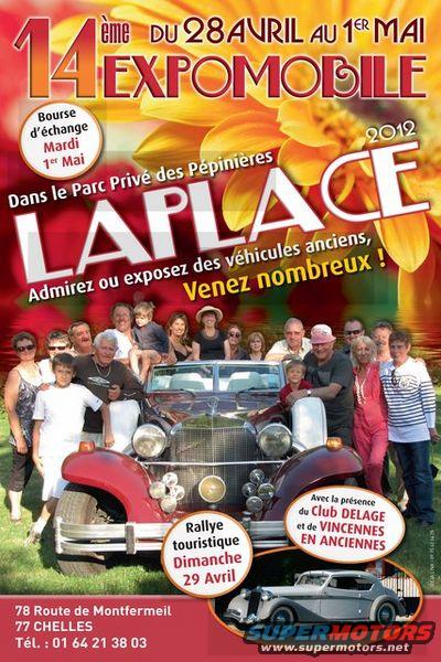 Red vintage car with a group of people posing in front