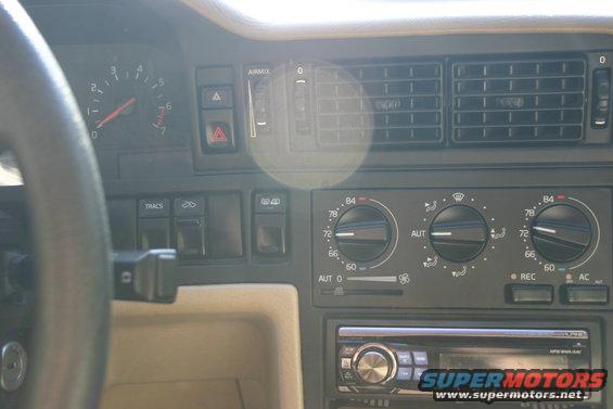 Car dashboard with tachometer, air vents, climate controls, and aftermarket stereo