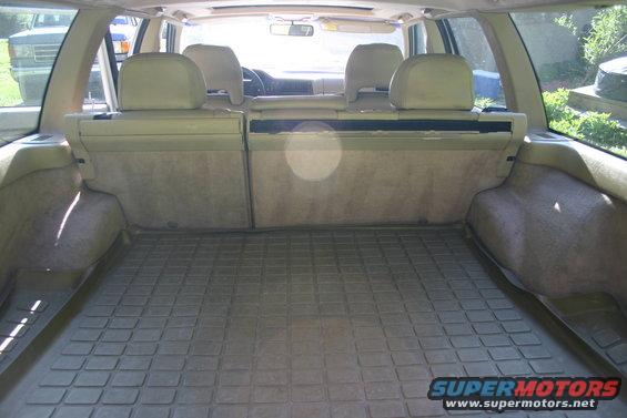 1997 Volvo 850 interior cargo area with rubber mat and folded rear seats. Another vehicle is visible through the rear window