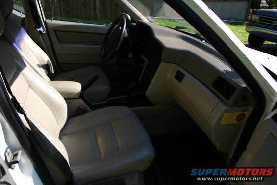 1997 Volvo 850 interior, beige leather seats, dashboard, and center console. Another vehicle is visible outside