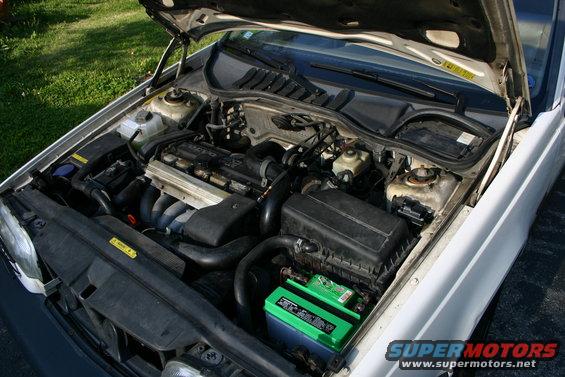 Engine bay of a 1997 Volvo 850, showing the engine, battery, and other components under the hood