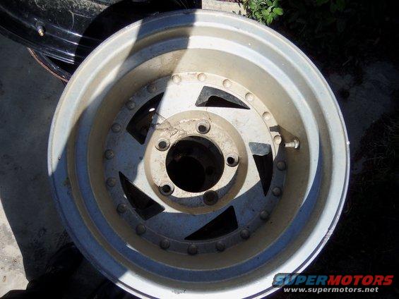 Aluminum alloy wheel with a five-spoke design and a silver finish, showing some wear and dirt