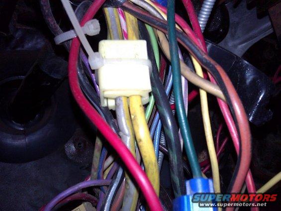 Close-up of a vehicle wiring harness with red, yellow, and purple wires